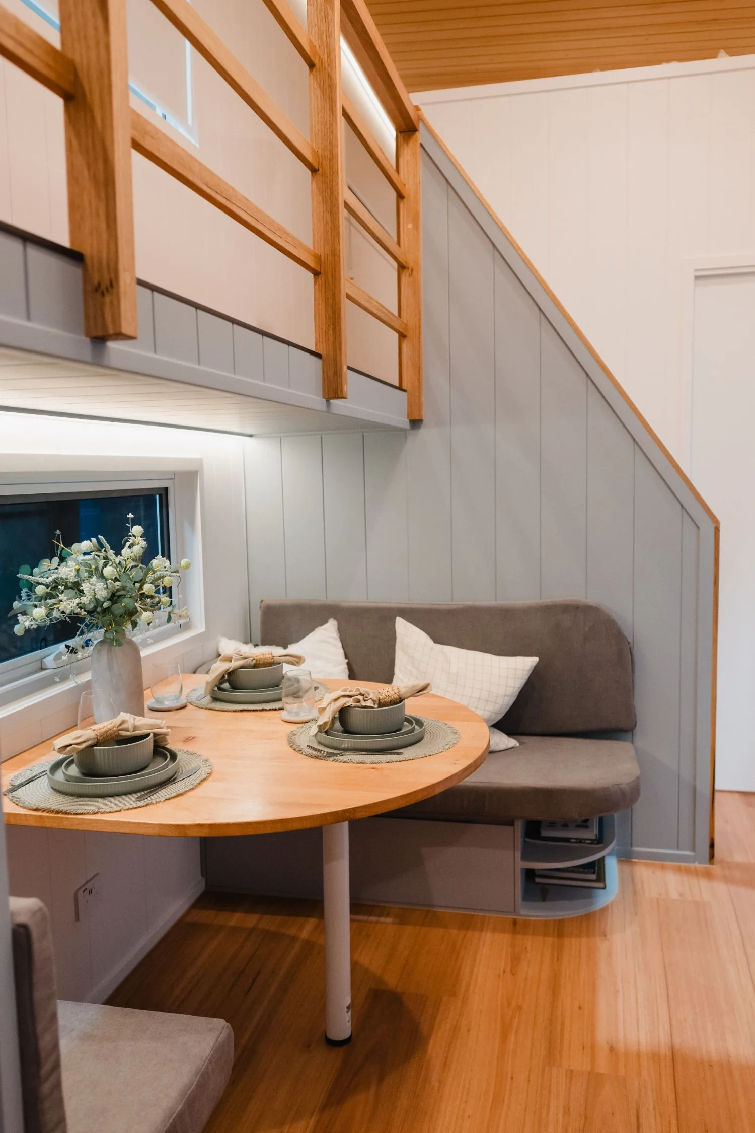 Serenity dining nook under the loft with a round timber table and bench seat