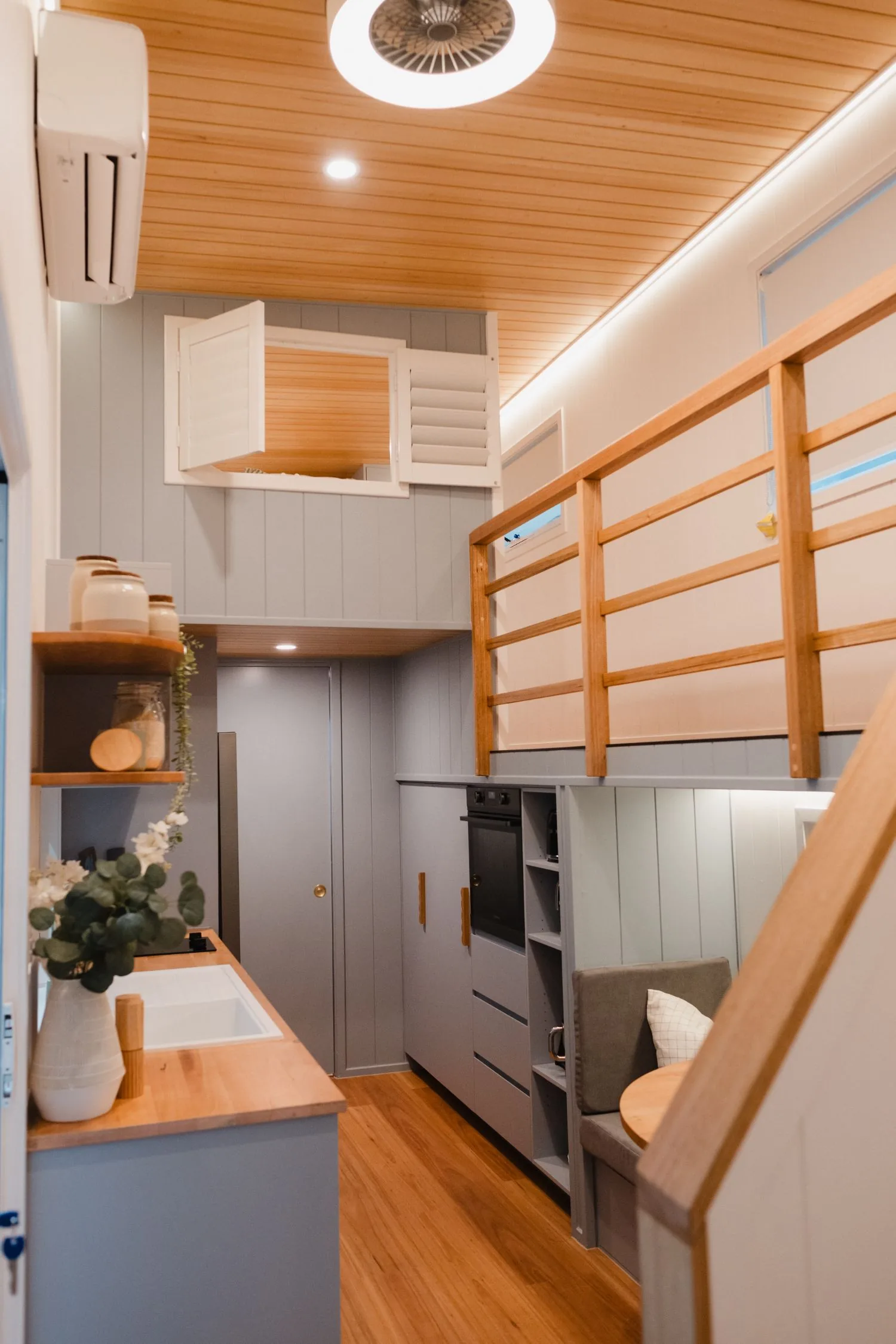 Serenity kitchen with oven tower and dining bench beside the loft stair